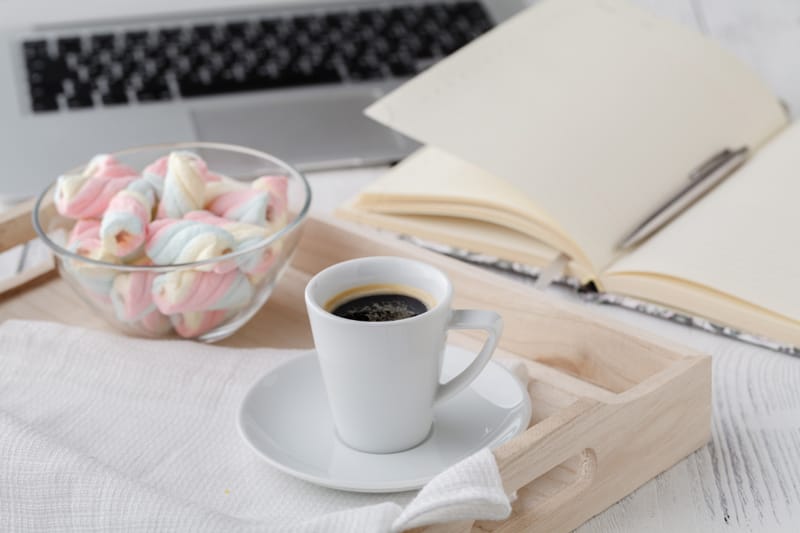 Tasse de café et carnet ouvert sur un bureau, symbole de l’écriture et de la création de contenu pour un site d’auteur.